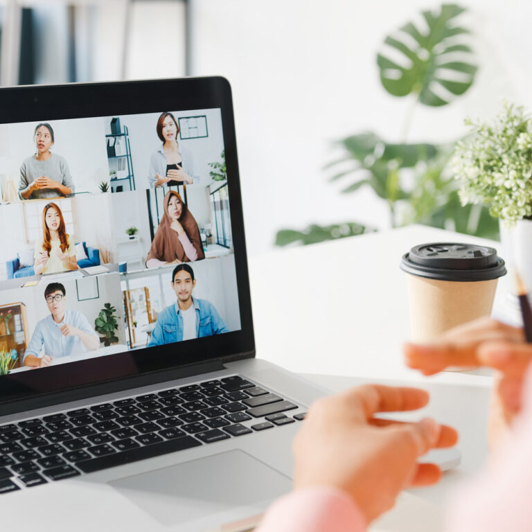 Eine Person nimmt am Laptop an einer Videokonferenz teil